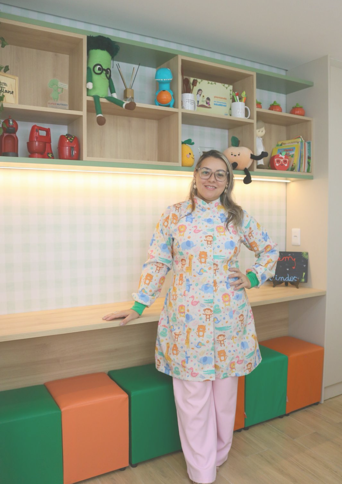 Cris Teles em seu consultório de nutrição infantil, com ambiente lúdico e acolhedor