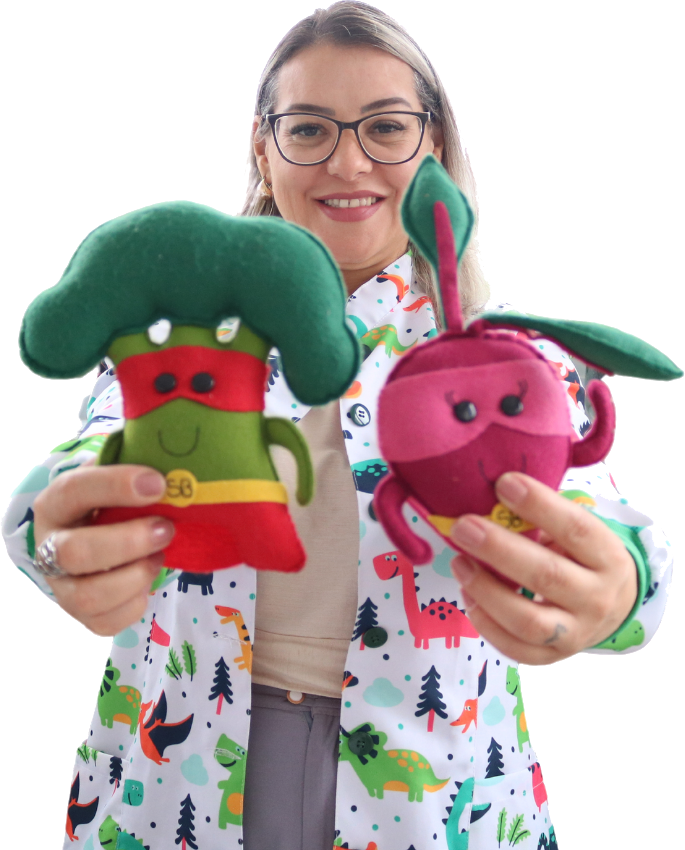 Cris Teles segurando os mascotes de feltro do consultório